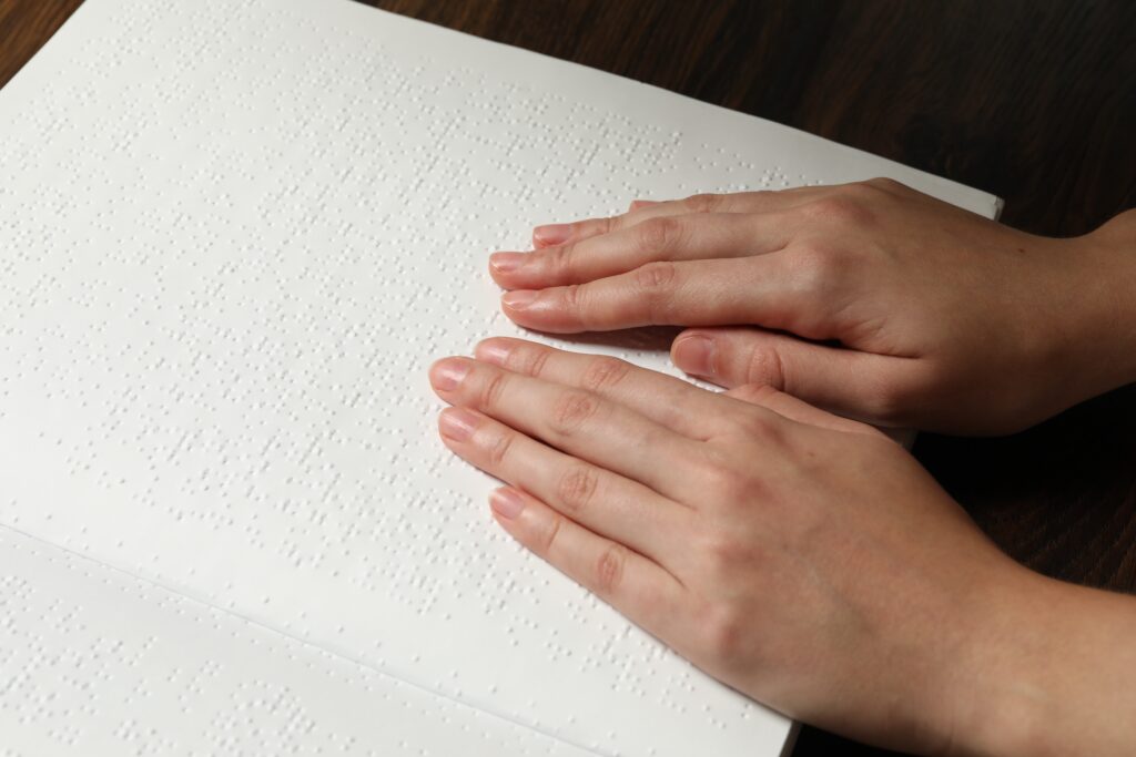 Illustration de mains lisant un texte en braille