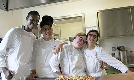 4 jeunes personnes porteuses de handicap travaillant ensemble dans une cantine