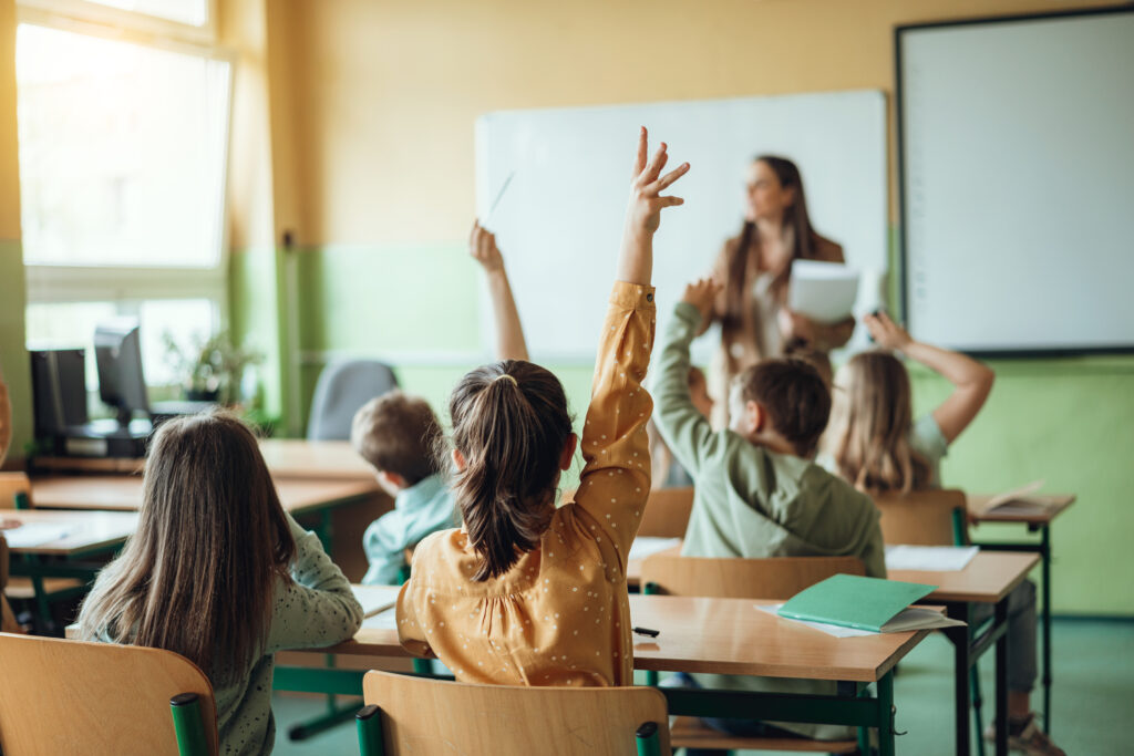 Illustration d'enfants de CM1 dans une salle de classe en train de lever la main